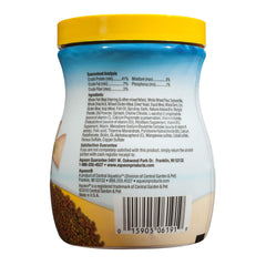 Aqueon Tropical Granules versés dans l'aquarium, granules qui coulent et nourrissent les poissons.