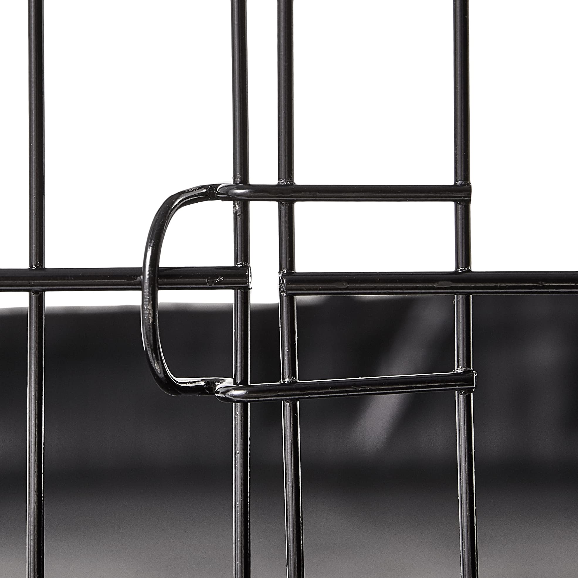 Cadre en fer robuste de la cage Amazon Basics offrant sécurité.