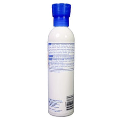 Main tenant le flacon, dosage précis pour traiter l’eau et protéger les poissons.