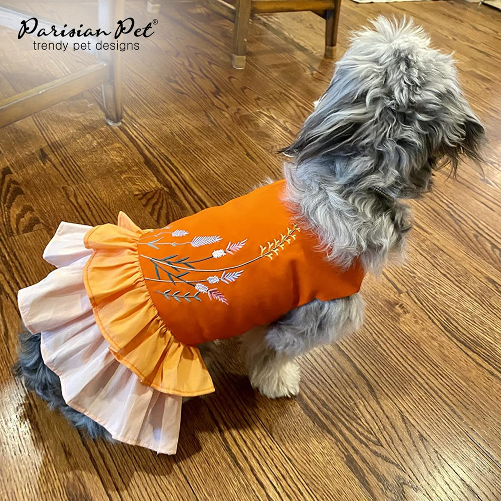 Couleur orange et accents floraux pour un look estival chic.