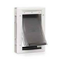 Porte PetSafe Extreme Weather ouverte sur une porte extérieure, accès facile pour animaux.