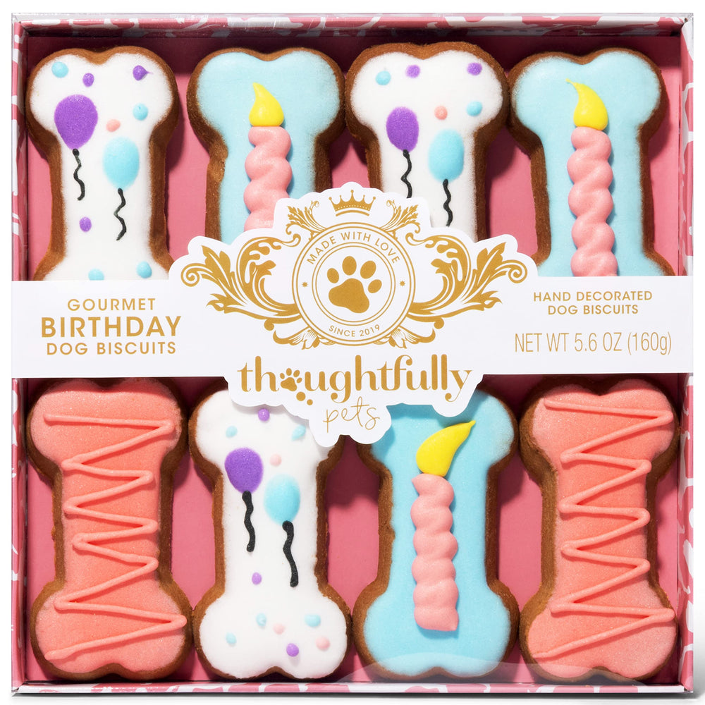 Thoughtfully Pets – Ambiance anniversaire chien avec biscuits-os rose sur table.