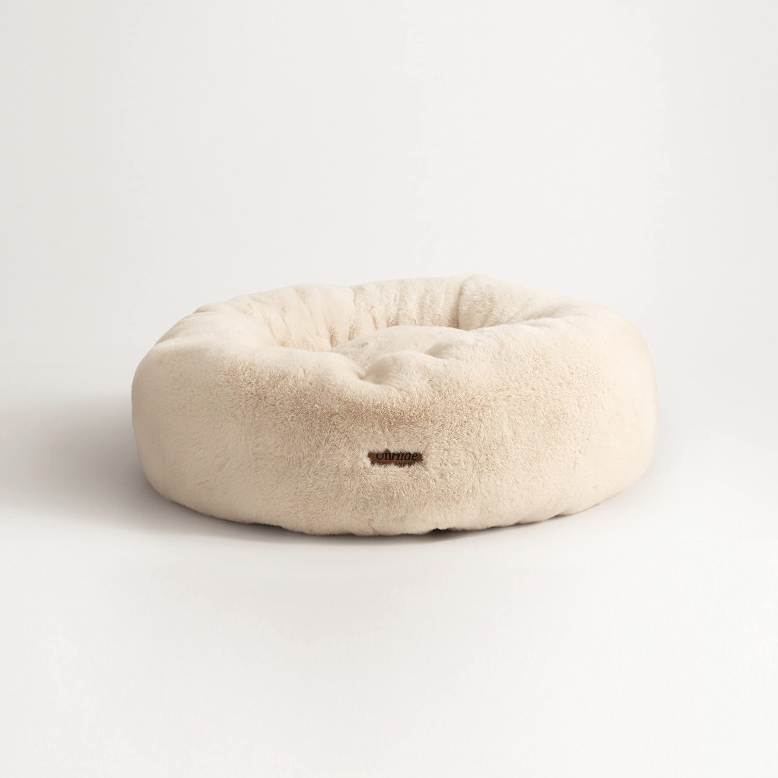Coussin bolster UnHide Floof offre un soutien confortable au chien.